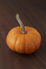 Cute orange pumpkin on wood table with