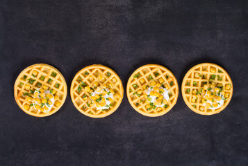 Vegan Round corn waffles with soft cottage cheese and greens. Dark background. Top view