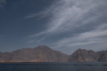 A view of Hajar Mountain taken from the Oman Gulf against a blue sky in Musandam Oman
