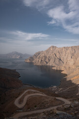 Fototapeta na wymiar A view of Khor Najd in Musandam Oman, with a winding road down to the beach