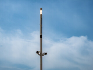 Surveillance cameras on a pole against the sky. Surveillance cameras for the object.