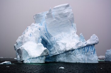 Photo of a massive iceberg gracefully floating in the vast expanse of the ocean