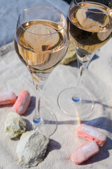 Tasting of grand cru sparkling rose wine with bubbles champagne with view on old houses of Oger, small village with grand cru vineyards, France.