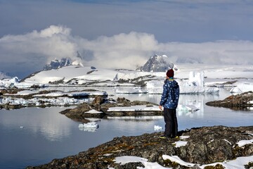 Photo of a man standing on top of a snow covered mountain in Antarctica during a cruise tour © turventur