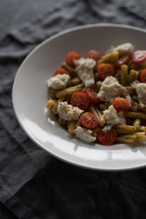 casarecce pasta with pesto, fresh cherry tomatoes and mozzarella