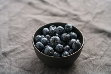 Freshly washed organic blueberries in a black bowl closeup