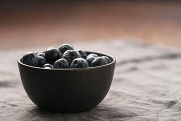 Freshly washed organic blueberries in a black bowl closeup