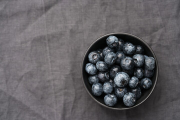 Freshly washed organic blueberries in a black bowl closeup