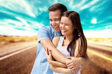 Obraz premium Happy young couple hug on outdoor background