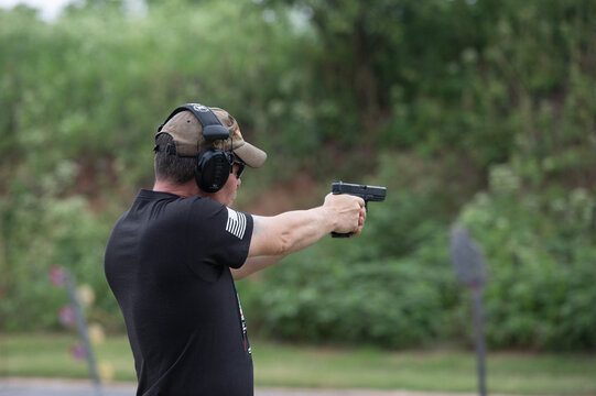 Man shooting with a gun at the outdoor range