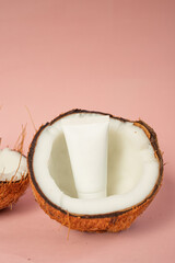 product shot of coconut cream in white packaging with natural coconut on a pink background