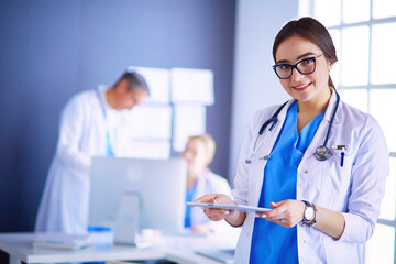 Female doctor using tablet computer in hospital lobby