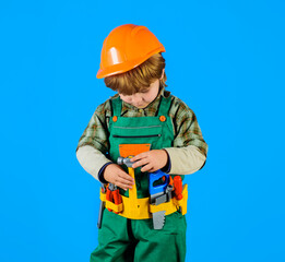 Little kid repairman with toolbelt. Tools for building. Builder boy in safety helmet and toy tools for repair. Little child in builder's uniform with tool belt. Work with tools. Child game. Repair.