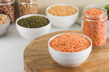 Red raw lentils in a bowl. The concept of vegetable protein. Horizontal photo.
