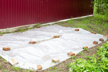 spring beds with planted seeds are covered with a transparent film to create a greenhouse effect. Gardening and horticulture