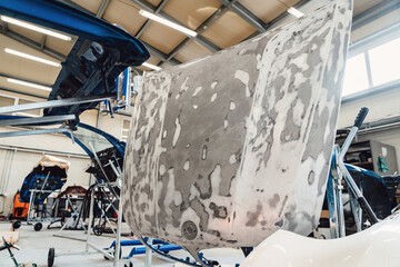Painting and drying of car body parts after applying putty and paint on hood in the body repair...