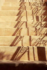 Brown earth tone stairs with the shades of the lights coming in making a pattern