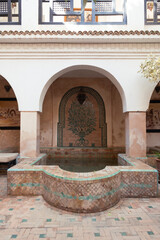 Moroccan indoor bath or pools with moorish arches, arabic tiles and architecture in the interior terrace of a riyad in Marrakech, Morocco.