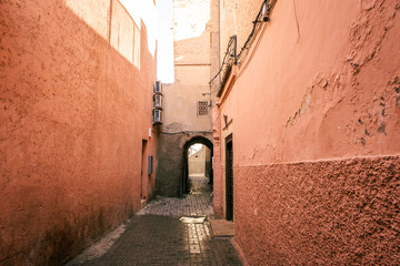 Street alley with pink walls inside the Marrakech Medina in Morocco