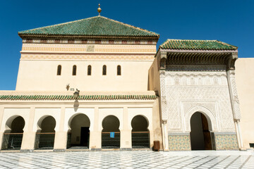 Fototapeta na wymiar A mosque with arabic architecture and moorish arches at a plaza in Marrakech, Morocco