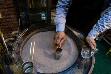 Turkish traditional method of making coffee with boiling hot sand in the streets of the Marrakech Medina in Morocco