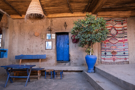 Inside a traditional berber house in the mountains of the Ourika Valley in Morocco with a persian rug and a stool