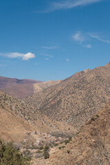 A town sits on the skirts of the mountains of the Ourika Valley in the High Atlas of Morocco