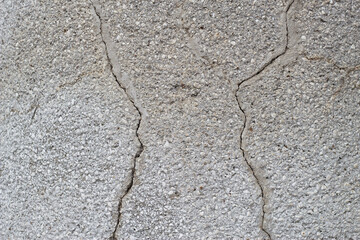close up of grey cracked plaster wall surface 