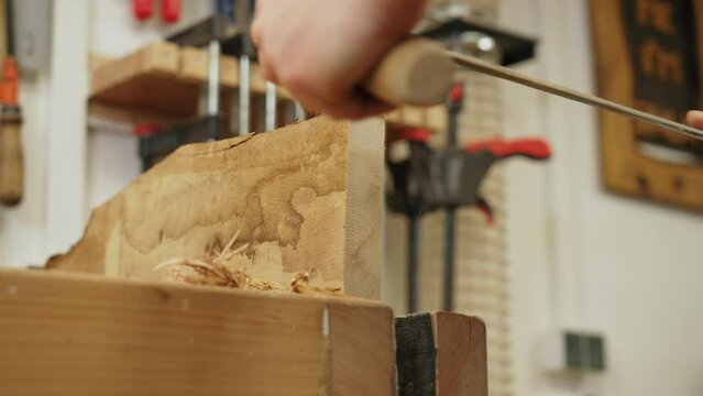 Carpenter using draw-shave knife tool to smooth out the wood in a carpenter workshop. High quality 4k footage