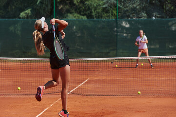 Young girls in a lively tennis match on a sunny day, demonstrating their skills and enthusiasm on a modern tennis court.