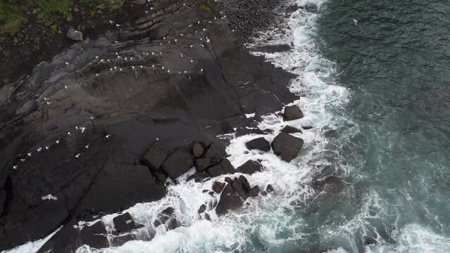 D&eacute;collage de mouettes depuis le r&eacute;cif espagnol avec le drone qui suit leur envol jusqu'&agrave; r&eacute;v&eacute;ler le paysage du coucher de soleil le long du littoral