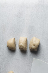 Bread dough divided into portions, process of making Swedish cinnamon buns or homemade Kanelbullar	