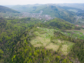 Naklejka na ściany i meble An aerial view of the mountain Yaremche town from above, green Carpathian mountains