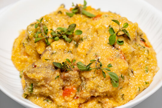 Traditional pork tenderloin recipe with corn grits and fresh marjoram (Origanum majorana). "Su&atilde;n com quirera".