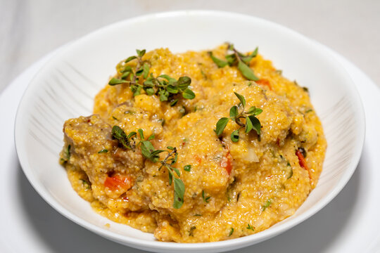 Traditional pork tenderloin recipe with corn grits and fresh marjoram (Origanum majorana). "Su&atilde;n com quirera".