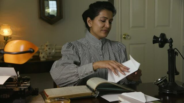 vintage woman reads a letter then uses telephone