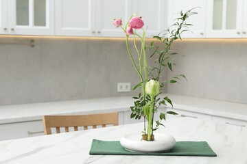 Ikebana art. Beautiful pink flowers and green branch carrying cozy atmosphere at home, space for text