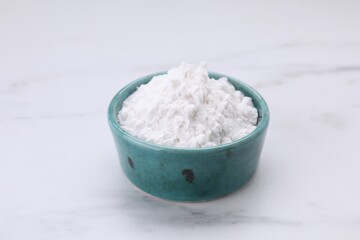 Bowl of natural starch on white marble table, closeup