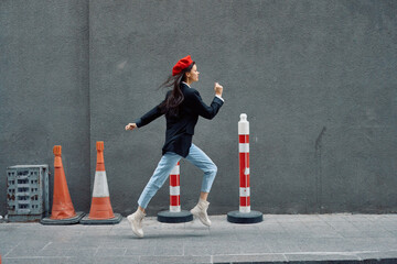 Fashion woman running down the street in front of the city tourist in stylish clothes with red lips and red beret, travel, cinematic color, retro vintage style.