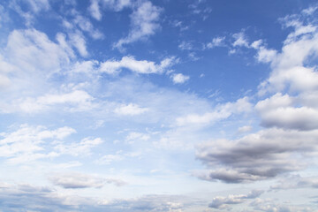 Beautiful blue sky with many white cirrus and fluffy clouds in sunlight, background texture, heaven
