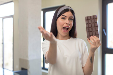 pretty young woman smiling happily and offering or showing a concept. chocolate concept