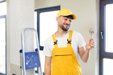 young handsome man smiling and looking with a happy confident expression. handyman concept