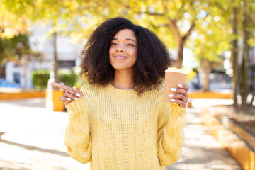 pretty afro black woman smiling cheerfully, feeling happy and pointing to the side. take away...