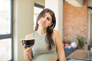 young woman feeling sad and whiney with an unhappy look and crying. ramen bowl