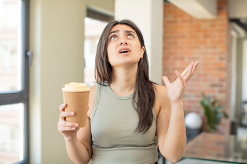 young woman screaming with hands up in the air. take away coffee