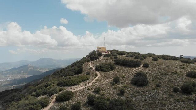 Hikers descend after climbing to the top of the summit El Menejador, Ibi, Alicante, Spain