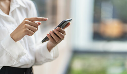 woman's hand with mobile phone Young woman tapping finger on blank screen of smartphone to click line and play social media online shopping job.