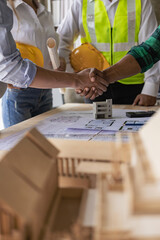 Obraz na płótnie Canvas Professional Asian male engineer shaking hands with male architect after meeting to build modern building. Professional team in industry and concept of engineers.