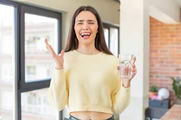 pretty young model screaming with hands up in the air. water glass concept