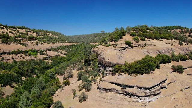 Aerial cinematic drone calvary cross Richard Springs YWAM Chico California Upper Bidwell Park butte cave creek canyon three cross on hillside crucifixion place of skull mid day sunny backward motion